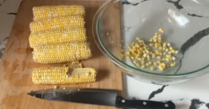 Honey Butter Skillet Corn in a cast iron skillet garnished with fresh herbs.