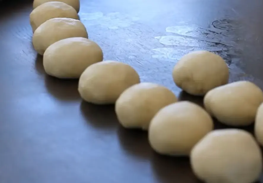 Freshly made homemade tortillas stacked on a wooden table.