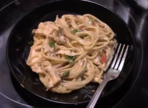 Uncooked fideo and spaghetti pasta side by side on a wooden surface.