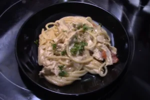 Uncooked fideo and spaghetti pasta side by side on a wooden surface.