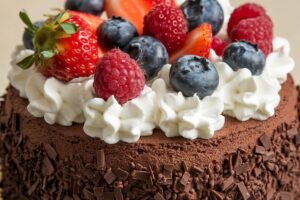 Moist chocolate cake with fresh fruit and whipped cream