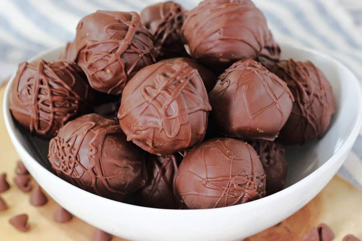 Chocolate-covered peanuts on a tray, coated with rich cocoa powder, showing a deliciously smooth and glossy chocolate coating.