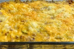 Bacon cheeseburger casserole with melted cheese and crispy bacon in a white casserole dish.