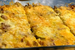 Bacon cheeseburger casserole with melted cheese and crispy bacon in a white casserole dish.